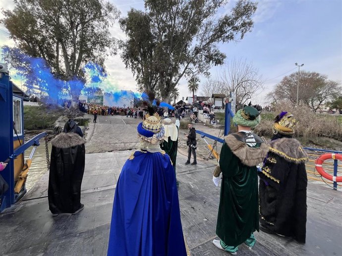 Los Reyes Magos llegan a Coria del Río en una barcaza que cruza el Guadalquivir.