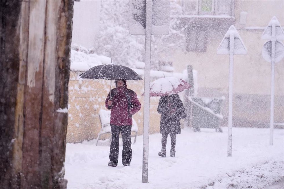 Archivo - Dos personas caminan por una calle cubierta de nieve.-ARCHIVO