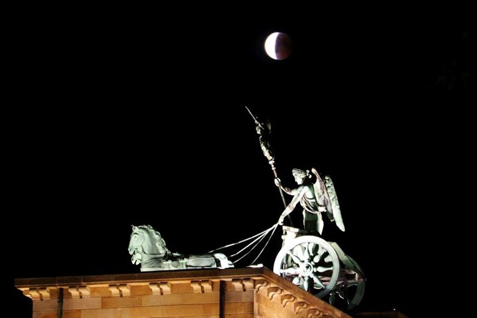 Archivo - July 27, 2018 - Berlin, Berlin-Tiergarten, Germany - For an hour and 43 minutes, the moon is completely submerged in the shadows of the earth. The moon then appears as a reddish disk in the sky. The photo shows the moon over the Brandenburg Gate