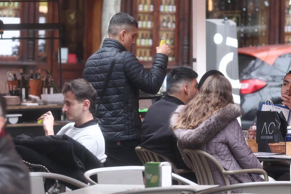 Camarero atendiendo clientes en una terraza.