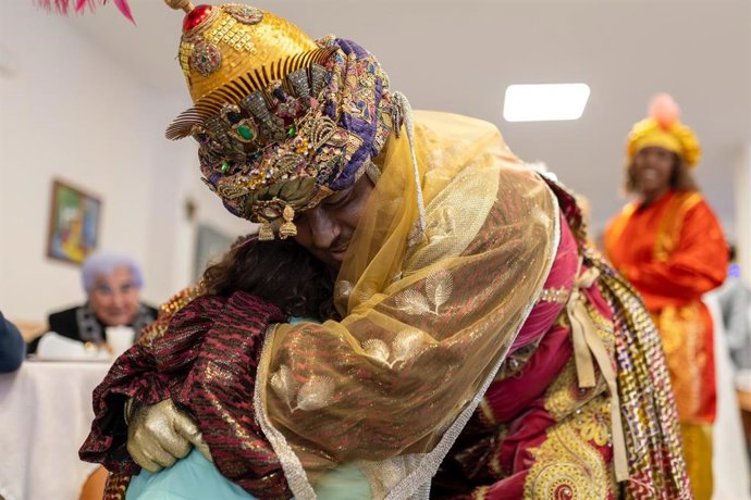 El Rey Baltasar abraza a una niña en una de las visitas.