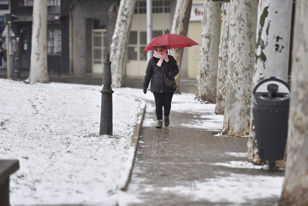 Archivo - Una mujer sujeta un paraguas mientras camina por una calle de nieve, a 10 de enero de 2024, en Jaca, Huesca, Aragón (España).