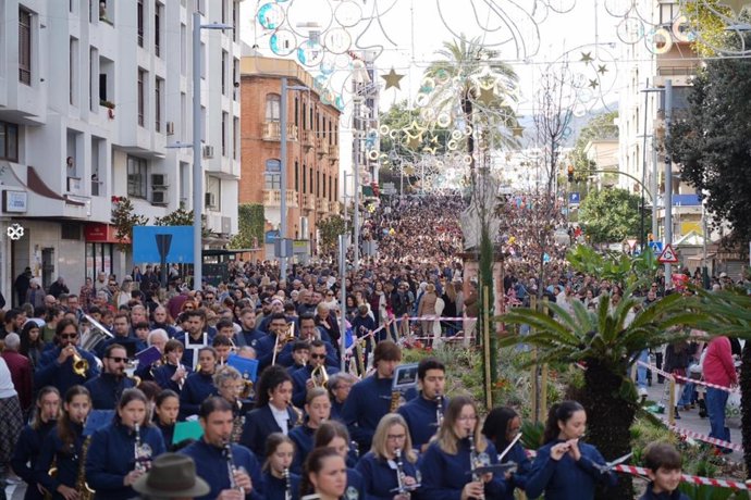 Multitud de personas participan en el tradicional arrastre de latas de Algeciras este 5 de enero de 2026.