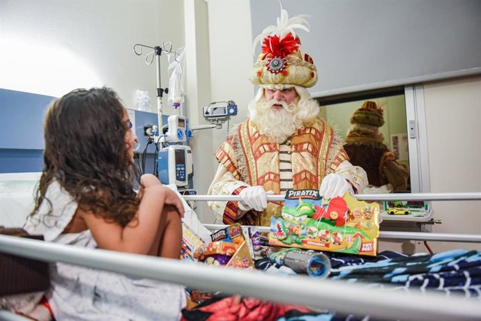 El Rey Melchor entrega un juguete a una niña hospitalizada en el Sant Joan de Déu de Barcelona.
