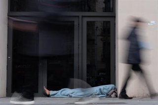 Imagen de archivo - Varias personas pasan delante de una persona sin hogar, en Barcelona