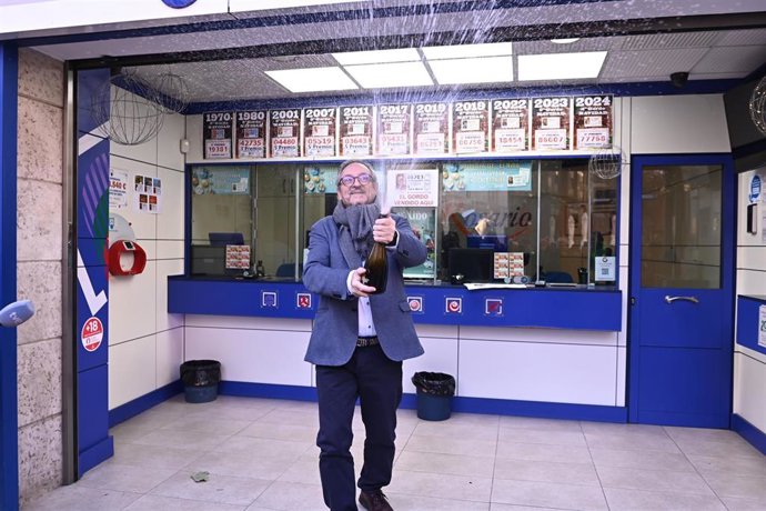 El propietario de la Lotería del Rosario, Alejandro Aznar, descorcha una botella de champán para celebrar la venta de diez décimos del sorteo de El Niño 2026, en Zaragoza.