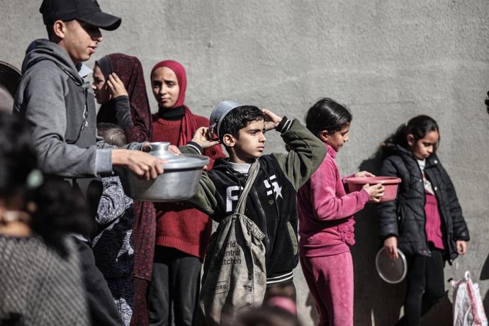 Palestinos en el campamento de Nuseirat, en el centro de Gaza, reciben comidas calientes de una organización benéfica destinadas a las personas desplazadas por los ataques israelíes. Foto: Moiz Salhi/APA Images vía ZUMA Press Wire/dpa