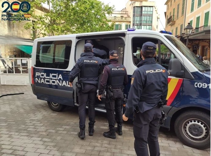 Agentes de la Policía Nacional junto a un vehículo.
