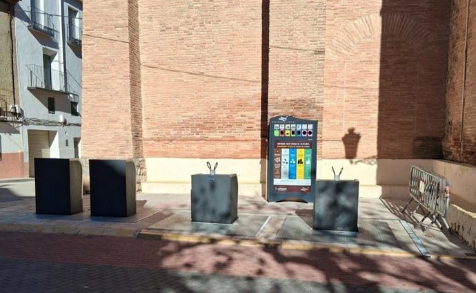 Contedores de residuos junto a la iglesia de Almonacid de la Sierra.