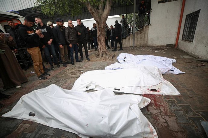 Palestinos junto a los cadáveres de varias personas muertas en un ataque de Israel contra un vehículo en la ciudad de Gaza, en el norte de la Franja de Gaza, a pesar del alto el fuego en vigor desde octubre de 2025 (archivo)