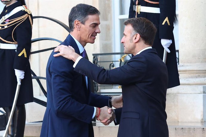 O Presidente do Governo, Pedro Sánchez (à esquerda), é recebido pelo Presidente da França, Emmanuel Macron (à direita), em sua chegada à reunião da Coalition of the Willing realizada no Palácio do Eliseu, em 6 de janeiro de 2026, em Paris (França).
