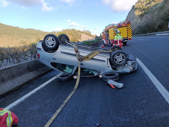 Turismo volcado sobre la carretera