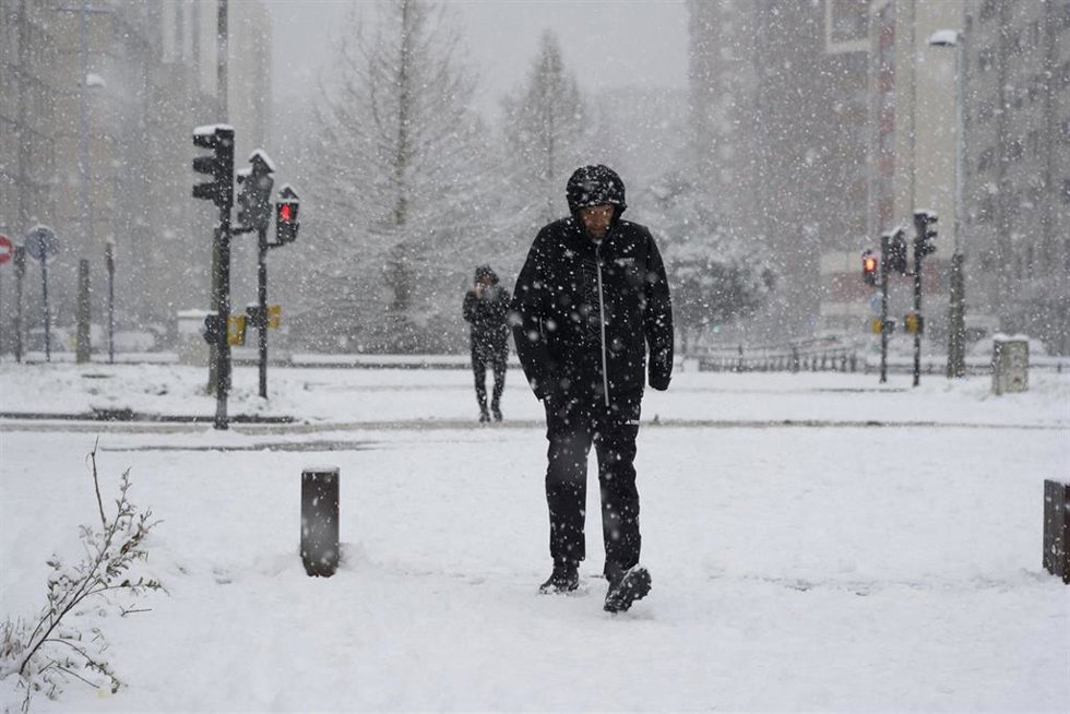 Varias personas disfrutan de la nieve en la calle de Vitoria