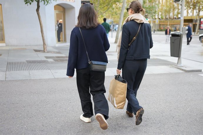 Archivo - Arxiu - Dos dones caminen enfront d'una tenda