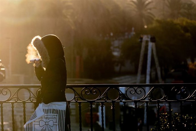 Transeúntes cruzan el Puente de Triana durante la ola de frío.