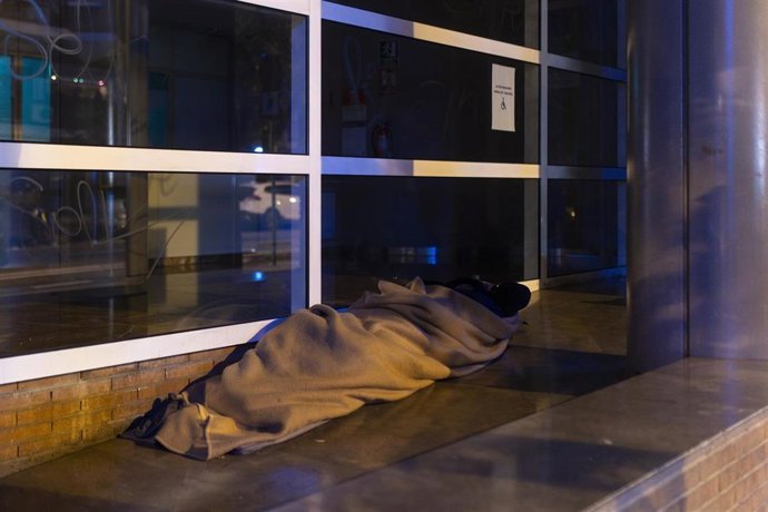 Archivo - Una persona sin hogar duerme en la calle en Barcelona, en una imagen de archivo.