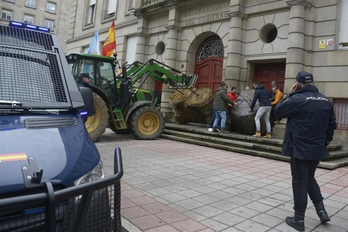Un tractor deja bala de paja, frente a la Subdelegación del Gobierno en Orense, a 7 de enero de 2026, en Orense, Galicia (España). Agricultores y ganaderos ha iniciado una nueva jornada de protestas en rechazo al acuerdo de libre comercio UE-Mercosur
