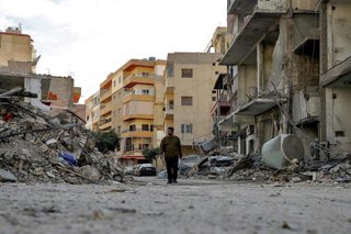 Archivo - Un hombre camina por una calle de Tiro, en Líbano, tras un ataque ejecutado por el Ejército de Israel (archivo)