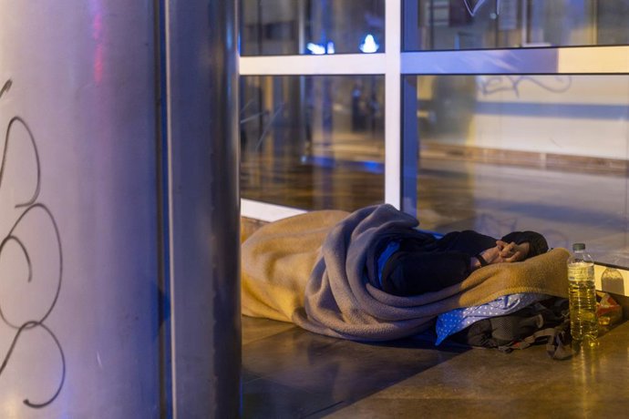 Archivo - Una persona sense llar dormint al carrer