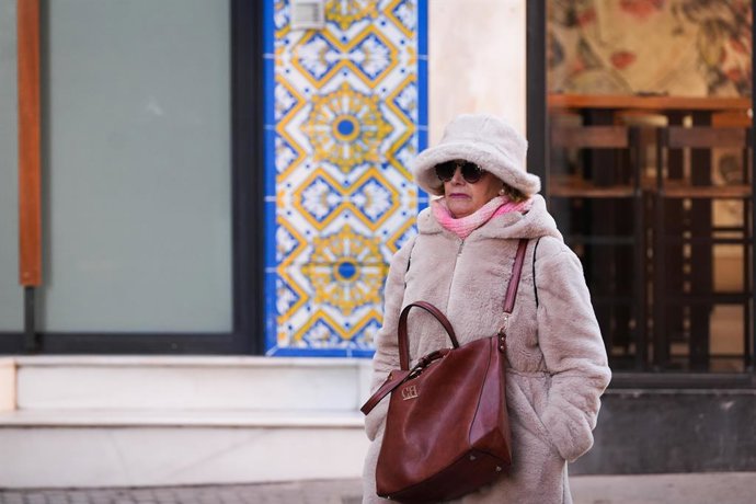 Imatge de transeünts sevillans protegint-se del fred a pocs dies de l'entrada oficial de l'hivern. 