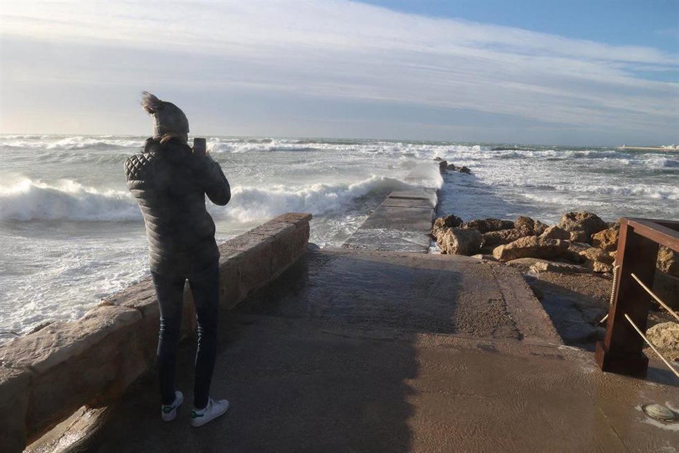 Archivo - Una persona fotografía el oleaje causado por el viento