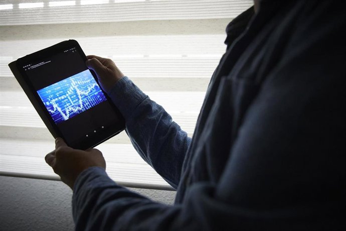 Archivo - Un hombre sujeta una tablet con un gráfico, a 4 de enero de 2022, en Madrid, (España). 