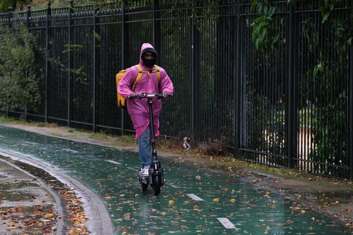 Archivo - Sevillanos protegiéndose de la lluvia y el viento, protagonistas de la jornada de hoy con avisos naranja y amarillo en gran parte de Andalucía. 