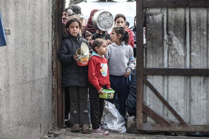 10 de janeiro de 2026, Nusairat, Faixa de Gaza, Território Palestino: Crianças palestinas aguardam para receber refeições quentes, distribuídas por uma organização de caridade, enquanto a crise alimentar continua devido à ajuda humanitária limitada no Cam