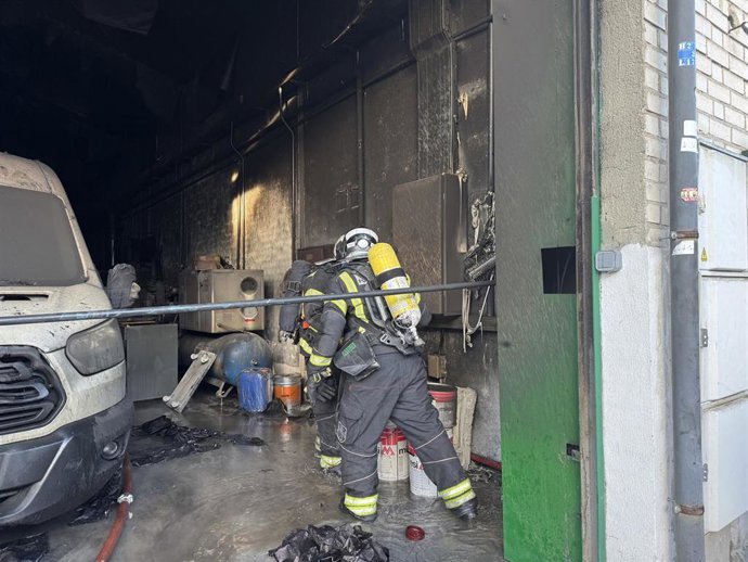 Bomberos de la Comunidad de Madrid trabajan en la extinción de un incendio en una nave industrial en Humanes.