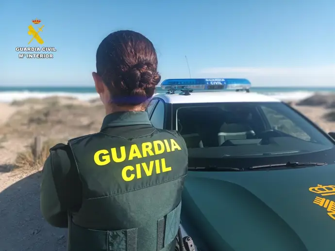 Agente de la Guardia Civil junto a vehículo