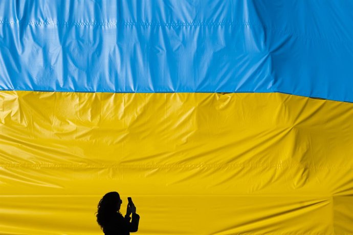 Archivo - Arquivo - 09 de março de 2022, República Tcheca, Praga: Uma mulher fotografa uma faixa com as cores da bandeira ucraniana pendurada no centro de Praga. Foto: Deml Ondřej/CTK/dpa