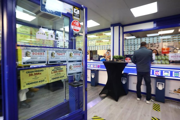 Administración de Loterías de San Lorenzo de El Escorial, situada en Calle del Rey 22, que han vendido 13 series del número 77.715 correspondiente a un Quinto Premio del Sorteo Extraordinario de la Lotería de Navidad 2025, a 22 de diciembre de 2025, en Sa