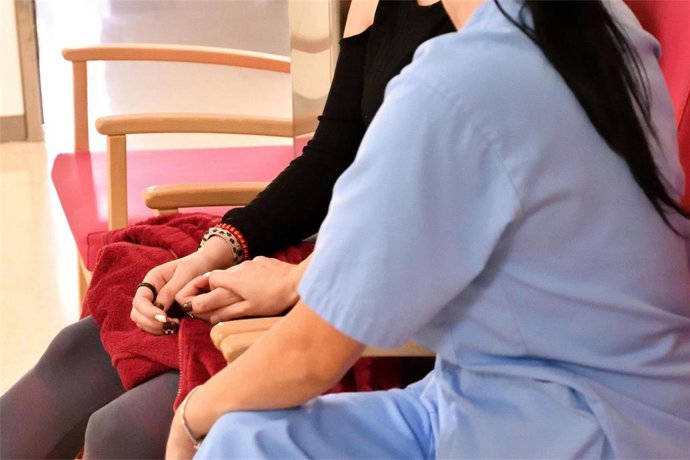 Enfermera cogiendo la mano a una paciente