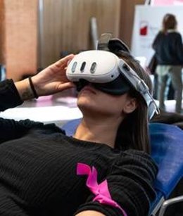 Una persona con gafas de realidad virtual mientras dona sangre
