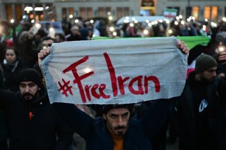 13 January 2026, Berlin: A demonstrator holds a sign reading "#FreeIran" during a demonstration at Paris Square in Berlin, in support of the nationwide mass protests against the government in Iran. Photo: Sebastian Christoph Gollnow/dpa