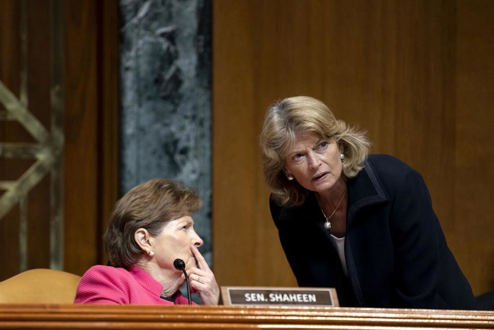 Archivo - La senadora republicana Lisa Murkowski (en pie, a la derecha) y la demócrata Jeanne Shaheen (izquierda) conversan en una sesión del Senado de Estados Unidos
