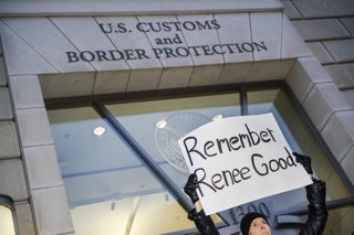 Un manifestant situat enfront de la seu del Servei de Control d'Immigració i Duanes (ICE) a Washington sosté una pancarta per denunciar l'assassinat de Renee Nicole Good a Minneapolis la setmana passada