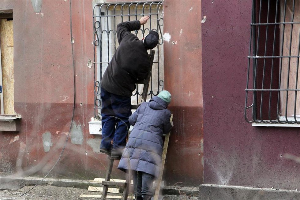 Archivo - Dos personas intentan arreglar los desperfectos causados por un bombardeo ruso en un edificio residencial en Krivói Rog, en la región ucraniana de Dnipropetrovsk