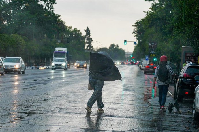 Archivo - Viandantes con paraguas por la zona del Parque de María Luisa, a 18 de mayo de 2023, en Sevilla, (Andalucía, España).