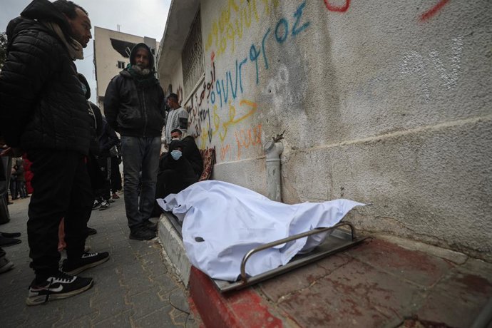 January 14, 2026, Gaza City, Gaza Strip, Palestinian Territory: Palestinians mourn over a body during the funeral of three displaced members of the Hamoda family who died after parts of a war-damaged building where they had taken shelter collapsed on a wi