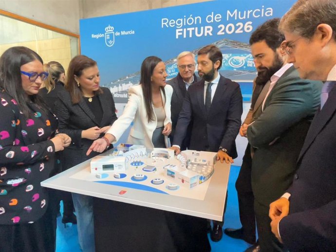 La consejera Carmen Conesa, con los directores generales del ámbito turístico y algunos alcaldes asistentes al acto de presentación de Fitur 2026, contemplando la maqueta del estand regional