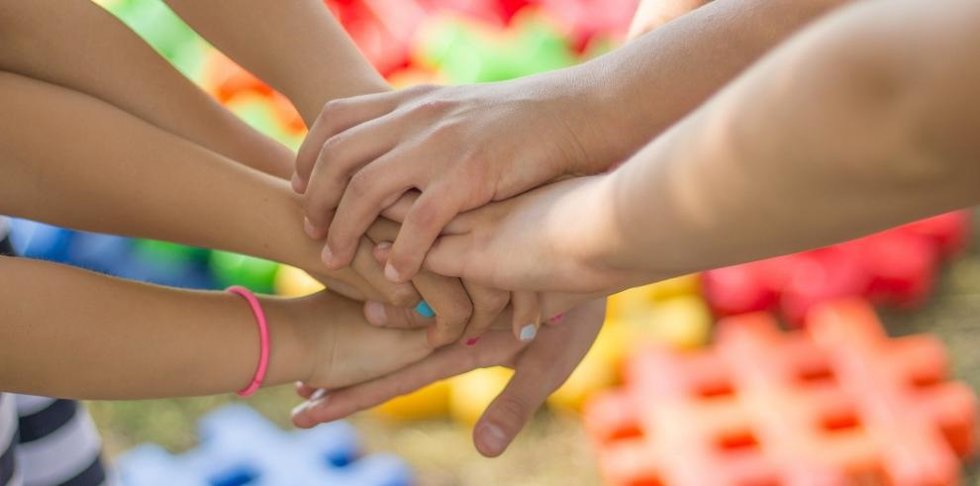 Niños unen sus manos durante un juego.
