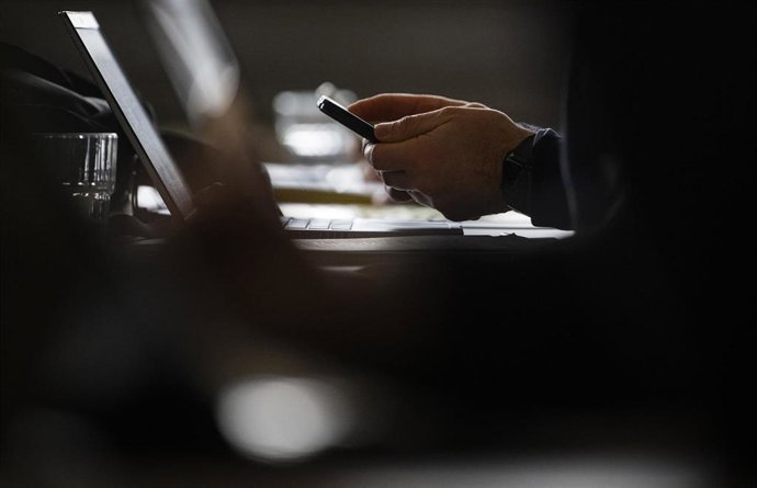 13 January 2026, Baden-Württemberg, Stuttgart: A journalist holds a smartphone during a press conference on the results of an analysis of the "Terrorgram scene". Photo: Marijan Murat/dpa