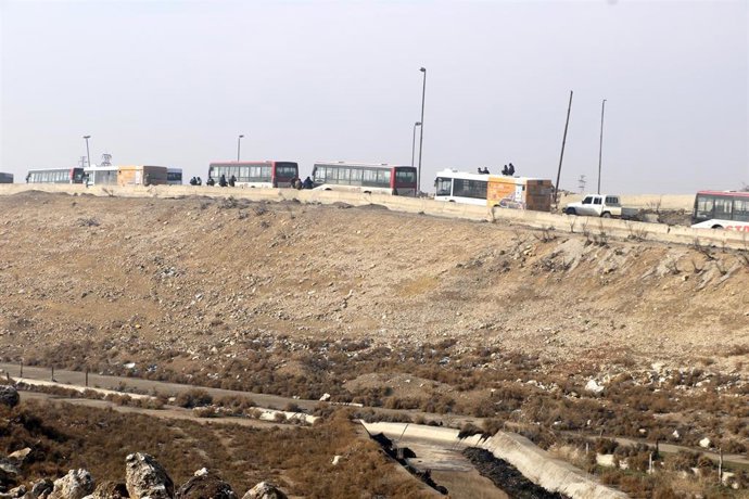 Archivo - Varios autobuses se dirigen al barrio de Sheij Masud en la ciudad de Alepo para facilitar una evacuación ordenada por el Ejército de Siria, en plena escalada militar contra las FDS