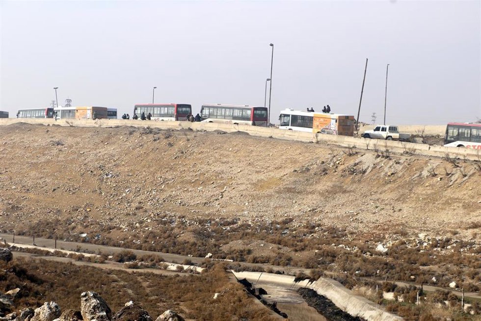 Archivo - Varios autobuses se dirigen al barrio de Sheij Masud en la ciudad de Alepo para facilitar una evacuación ordenada por el Ejército de Siria, en plena escalada militar contra las FDS