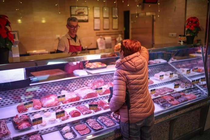 Una mujer comprando en una carnicería