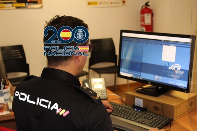 Archivo - Agente de la Policía Nacional delante de un ordenador.