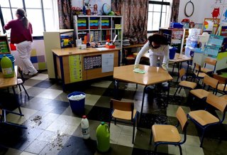 Trabajadoras del servicio de limpieza de colegios en un aula de un CEIP de Jerez de la Frontera (Cádiz)