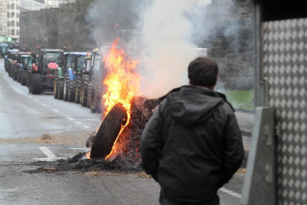 Hoguera de manifestantes de la tractorada que rodea la Muralla de Lugo desde el pasado lunes, frente a la Delegación de la Xunta de Galicia en Lugo, a 14 de enero de 2026, en Lugo, Galicia (España). Los ganaderos y agricultores gallegos continúan en pie