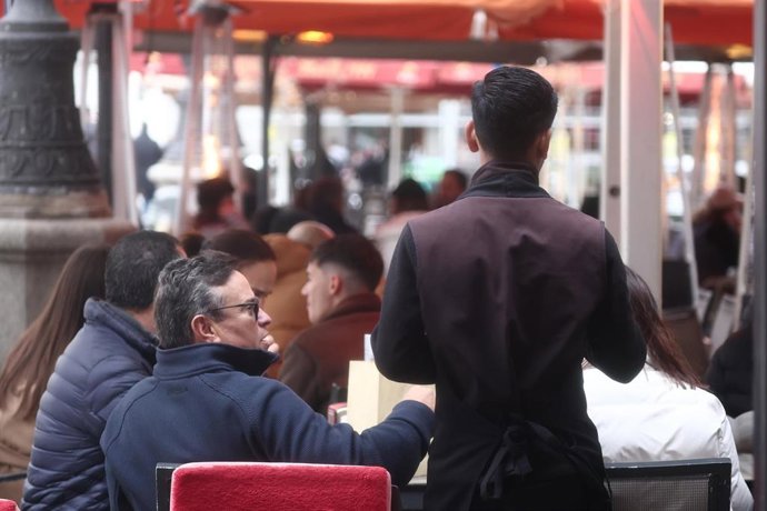 Camarero atendiendo clientes en una terraza, a 19 de diciembre de 2025, en Madrid (España). 